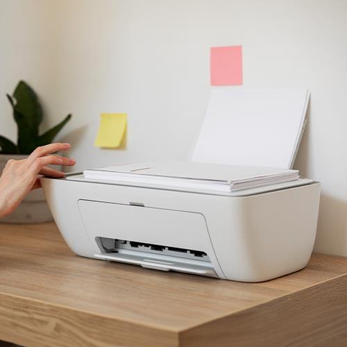 A Person Pointing to a Printer on a Desk, Representing the Convenience of Order Checks Online and Printing on Demand to Simplify Finances