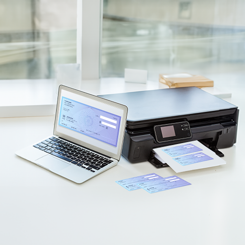 Laptop and Printer Sit on a Table. Business Check Printing Software Is Used to Print Checks