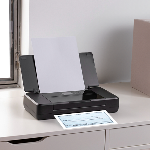 A Desk Is Topped with a Printer. The Printer Prints Checks Using a Free Check Generator