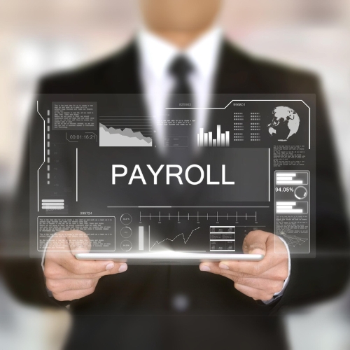 A Man Holding a Tablet Displaying the Word Payroll, Symbolizing the Integration of Technology in Payroll Companies.