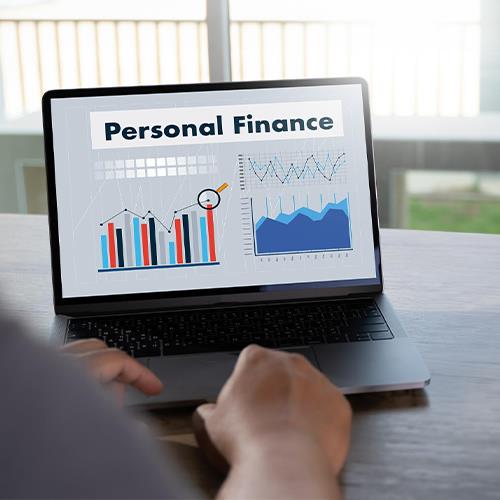A Person Engaging in Personal Finance Planning by Using a Laptop Displaying the Words Personal Finance.