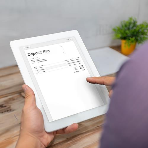 A Person Holding a Tablet Displaying Information on What Is A Deposit Slip