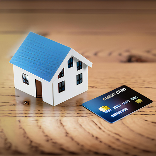 A Miniature House Model Beside a Credit Card on a Wooden Surface. The Process Is Currently Processing Smoothly to Pay Your Rent with a Credit Card