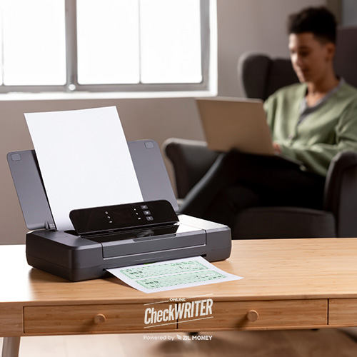 A Man Engaged in Check Printing at Home. The Printer Was Placed on a Wooden Desk