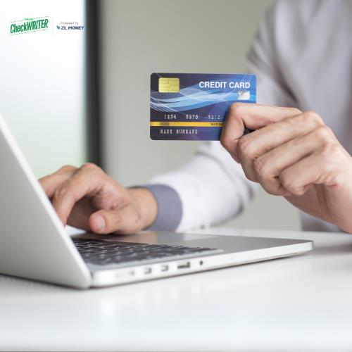 A Person Holding a Credit Card and Typing a Laptop, Illustrating the Concept of Pay Taxes With Credit Card