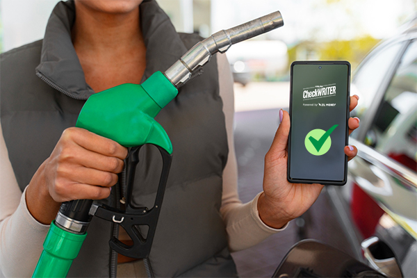 A Pesron Holding a Gas Pump ANd a Smartphone, Best Gas Station Payments Management Software You Can Find