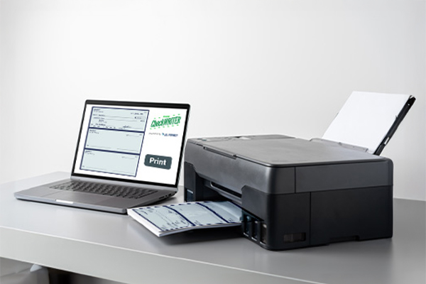 A Laptop And A Printer Printing Checks, Making Payments Easier With Check Writing Software. Print Efficiently And Cost Savings For Business