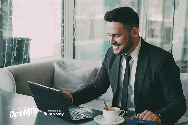 A Man Using A Laptop to Make Payments Easily. Revolutionize Payments with a Check Generator
