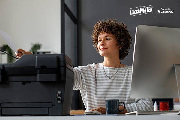 A Woman Using A Computer and Printer to Print Checks Online. This Image Represents Inexpensive Checks Online. A Smarter Way to Save on Business Payments