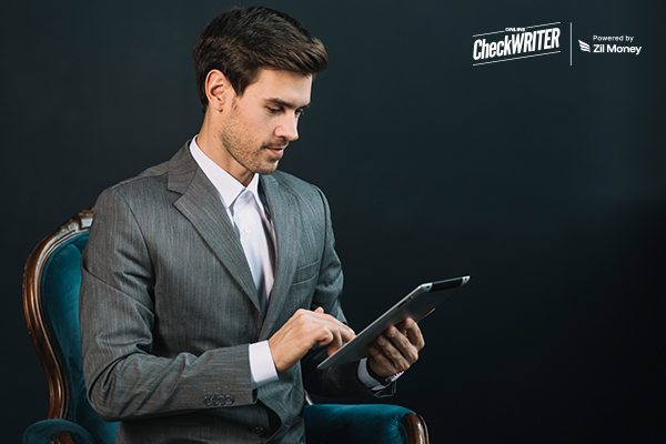 A Man Holding A Tablet To Make Vendor Payments. Streamline Vendor Payments Through Seamless Integration with NetSuite. Automate Checks, ACH, Wire, and Bulk Processing Workflows