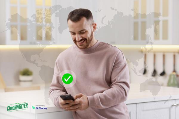 A Man Using A Phone to Make an International Payment Fast. Access ACH, Wire & Virtual Card