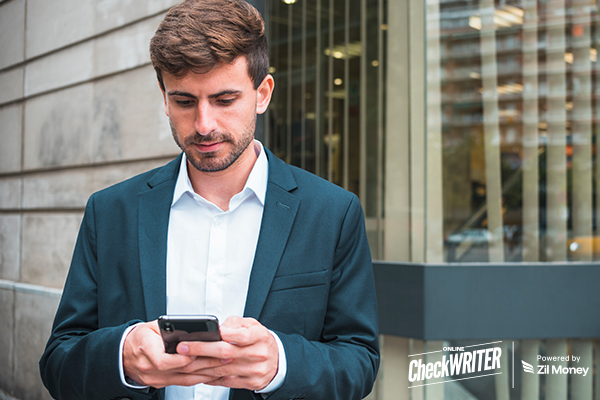 A man in a suit using his phone to Request Payment quickly and securely while on the go.