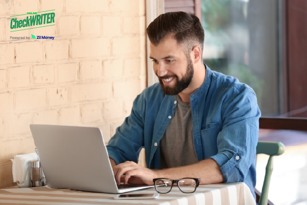 A Man Using a Laptop at a Café Shows How eChecks Make Vendor Payments Quick and Convenient.