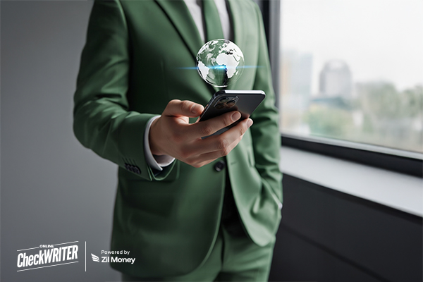 A man in a green suit uses a smartphone, symbolizing fast and secure International Payments anywhere.