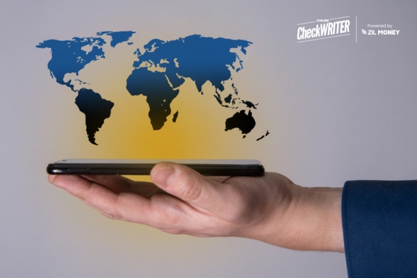 A Hand Holds a Smartphone with a Holographic Map of the World Hovering Above It, Representing Easy International Payments.