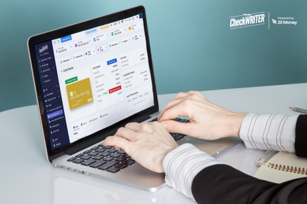 Hands typing on a laptop screen showing a dashboard for managing an Employee Bonus Card and transactions.