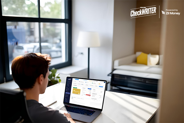 A young professional works on a laptop, viewing financial reports and a virtual Team Expense Management Card on the screen, emphasizing easy financial control.