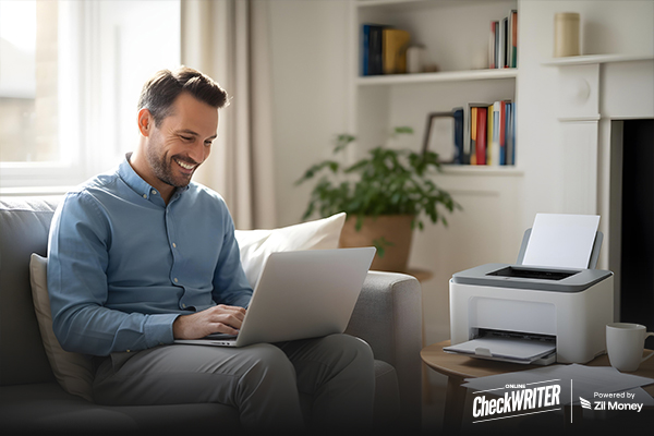 Best Business Checks in 2025: What Makes This Solution Stand Out Man smiling while printing business checks at home using a laptop and printer, representing easy online check printing.