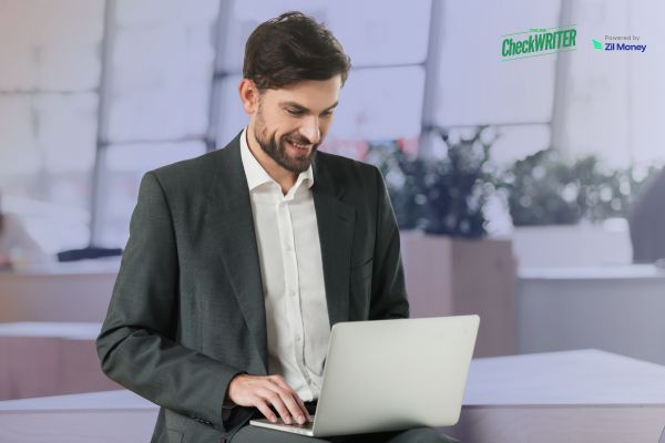 Outgrowing Manual Check Reviews Why Positive Pay Becomes Necessary A business professional using a laptop to monitor payments, highlighting secure Positive Pay Implementation for check fraud prevention.