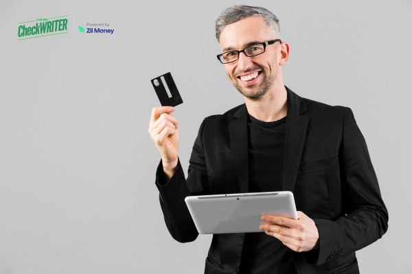How New Businesses Use Credit Card Payments Before Revenue Stabilizes A man holding a credit card and tablet, smiling as he demonstrates the ease of making a credit card payment for business transactions.