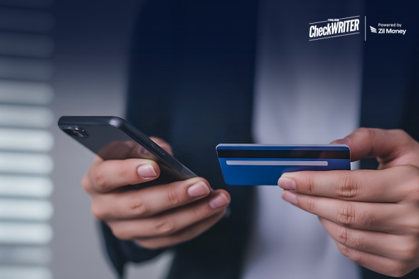 Fund Payroll by Credit Card A Smarter Move for Small Businesses Running Tight on Cash Business owner using a smartphone and card to Fund Payroll by Credit Card, showing quick digital payroll payment.