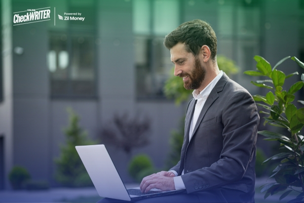Why Businesses Still Depend on Check Payments – Even as Payment Options Expand Professional in a suit uses a laptop to show Why Businesses Still Depend on Check Payments for secure transactions.