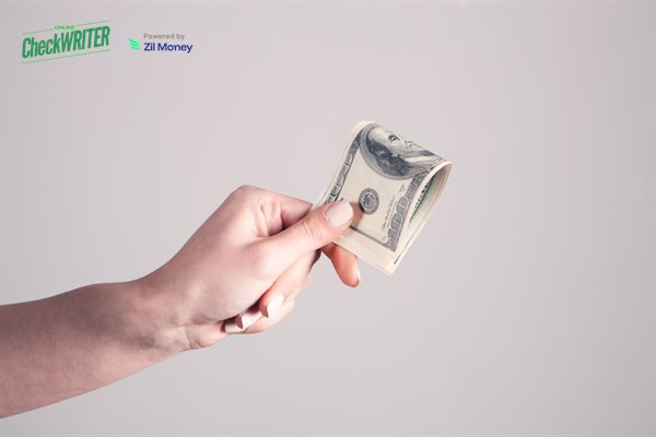 6 Ways to Process Bulk Payments Without the Month-End Chaos Hand holding cash representing bulk payments processed in one batch