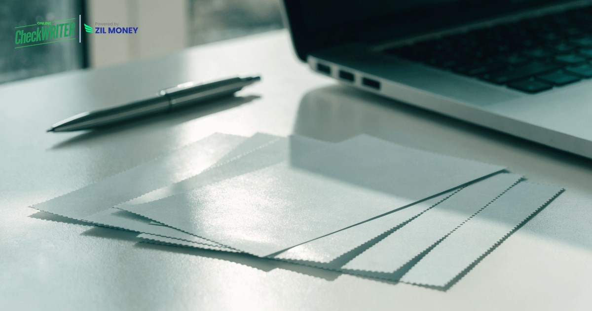 Get Wells Fargo Checks Online v3 Blank business checks fanned on a desk beside a laptop, ready to get Wells Fargo checks online