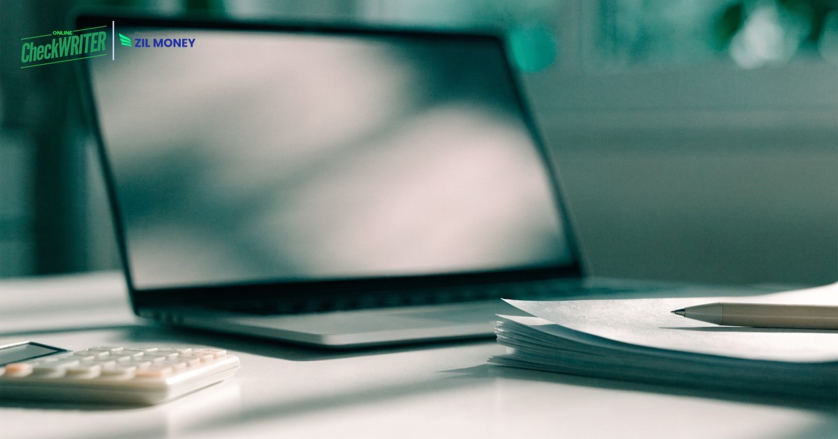 Online Checkbook Register v3 Laptop, calculator and paperwork on a desk for maintaining an online checkbook register